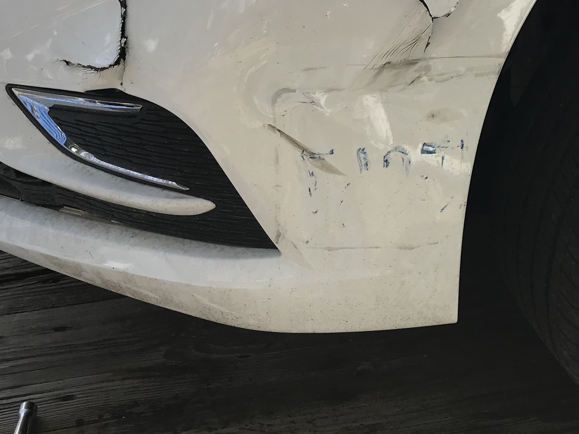 Car bumper of crashed car with letters from the license plate that impacted it 