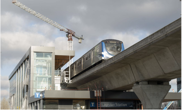 A Canada Line train seen from ground level passing through Capstan station with a construction crane in the background

Translink photo 