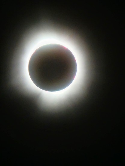 The sun in totality. The sky and the center of the sun (actually the moon) are completely black, and there is a halo of screamingly bright white extending in an uneven circle around the sun. In the photo the halo is kind of a blur, in reality you could see individual sharp spikes of white.