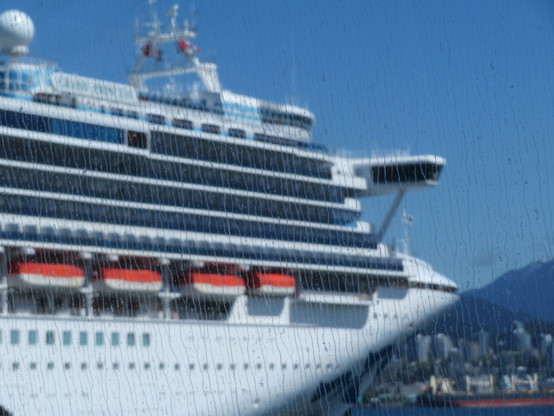 The front end of a large cruise ship in dock at Vancouver. The window of the ferry has not been cleaned effectively