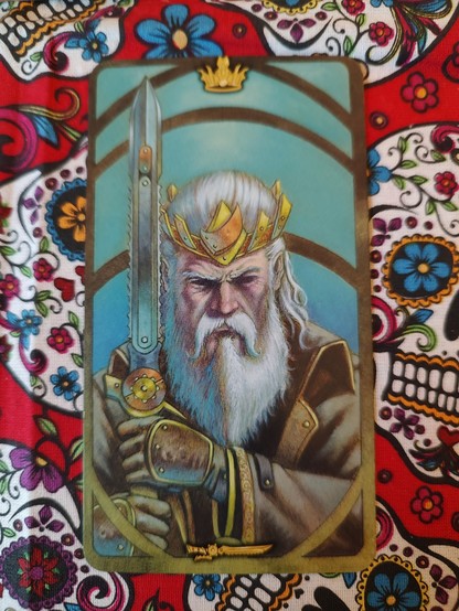 Card from the Steampunk Art Nouveau Tarot deck. 
King of Swords. 
A king, older man with white beard, crown, holding a sword pointed up. He does have a face of not taking guff from anybody.