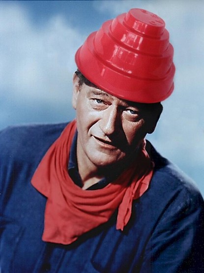 John Wayne wearing a blue shirt, a red kerchief, and a red devo hat