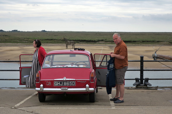 Beautifully restored Morris 1100 'Martha' and her owners arriving on the quayside from Kent, lifeboat horse on sand across the channel and bowsprit of the Albatros, muted colours but lovely red on the car and matching cardi
