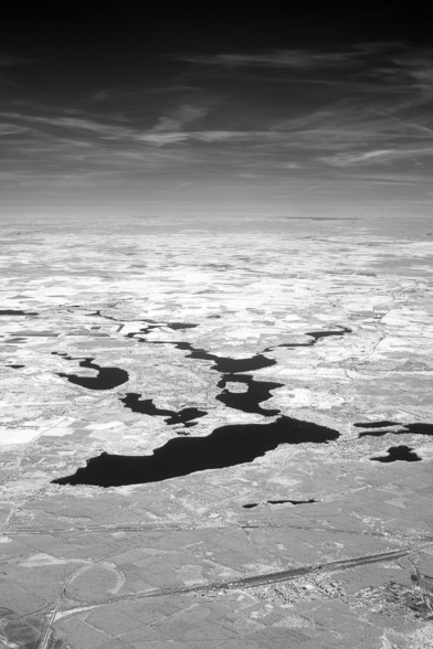 Image description
Lakes like puddles of ink on a white landscape under a black sky