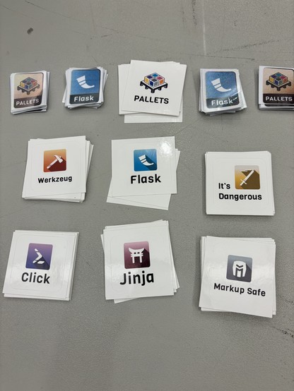 11 piles of stickers, with logos and names for Pallets, Flask, Werkzeug, Jinja, Click, It's Dangerous, and Markup Safe.