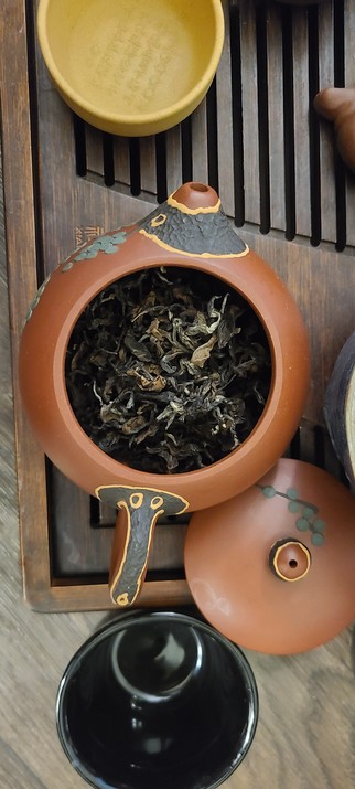 Dried dongfang meiren waits in my zisha pot. White tips mix with dark twisted buds and flat light brown leaves with nibbles from the tea jassid
