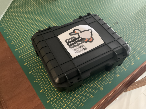 A black plastic pelican-like case with a sticker on it that reads 