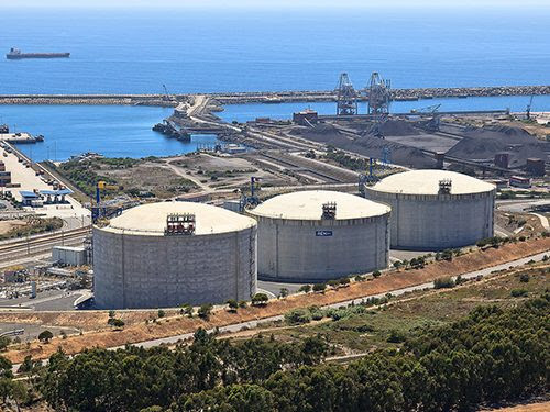 Three huge gas tanks adjacent to a port