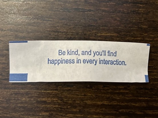 A fortune cookie fortune that reads, “Be kind and you’ll find happiness in every interaction.”