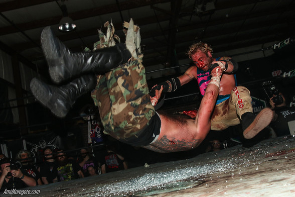 Colby Corino with an assault driver on Toby Farley onto a field of broken glass chips