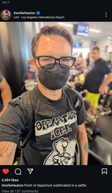 Instagram post by Wil Wheaton on July 2

Photo of Wil wearing a black tri-fold or boat-fold earloop respirator, black rimmed glasses and a black t-shirt with the words Operation iCEE and a bear on it. He is also carrying a backpack. In the background are several people in a room.
The post says the location is LAX - Los Angeles International Airport.
Wil Wheaton has written Point of departure sublimated in a selfie. 