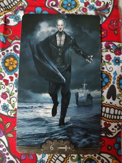 Card from the Tarot V deck. 
Six of Swords.
A male vampire, dressed in black, long cape mostly draped over his right arm, is walking over water. Appears to be a shoreline or beach, there is a wrecked cargo ship a bit behind him. It is dark, sky is mostly grey, cloudy. He is a thin, balding man with deep eyes. 