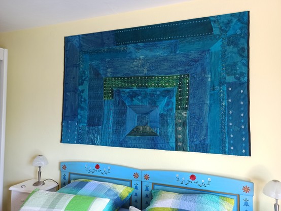 Schafzimmer mit Bauernbetten und blauem Wandbehang im Orientstyle