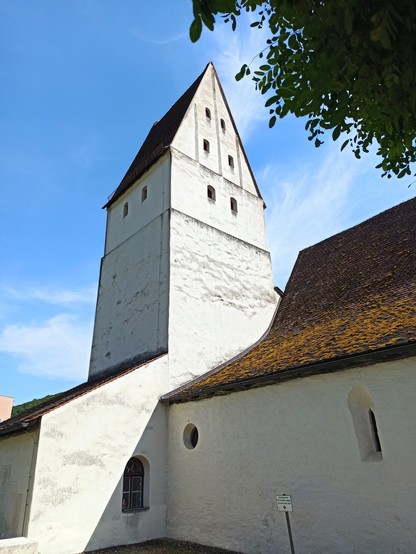 Kirche aus einer anderen Perspektive, weiß, kleine Fenster spitzes Dach mit Moos