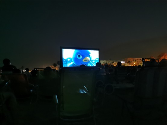 Se ve una pantalla gigante en una playa