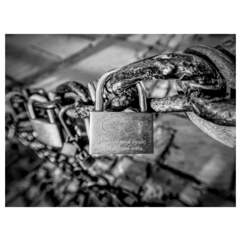 Black and white photo of lovelocks on a chain