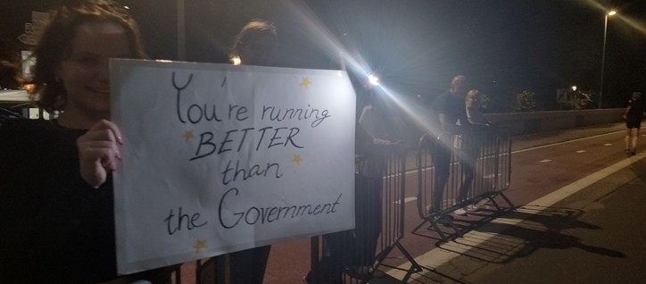 Photo of a young woman holding a sign that says 