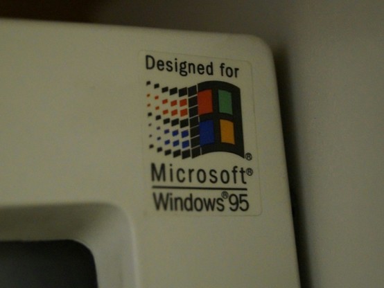 Photo of a sticker reading "Designed for Windows 95" on the screen of an old PC of the 1990s