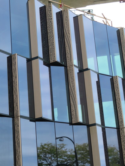 Nice detail feature of new building being constructed with overlapping windows - the leading edges of the uprights contain a variety of decorative additions