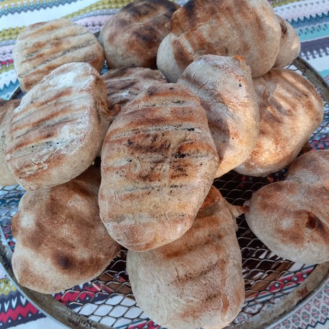 Homemade rolls baked on the barbecue. Grill marks appear on each one.