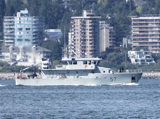 A small grey ship with the number 57 on the hull