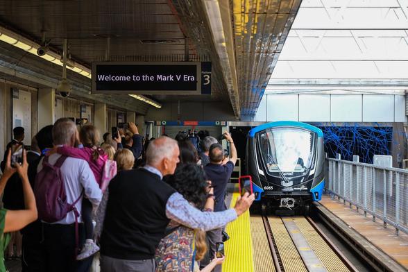 Passengers waiting on the platform as a new blue train arrives.