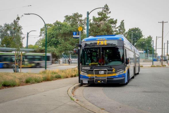 A single deck Translink articulated bus with a destination  sign that reads

PNE  